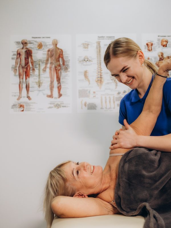 a retired woman visits a rehabilitation therapist for a massage